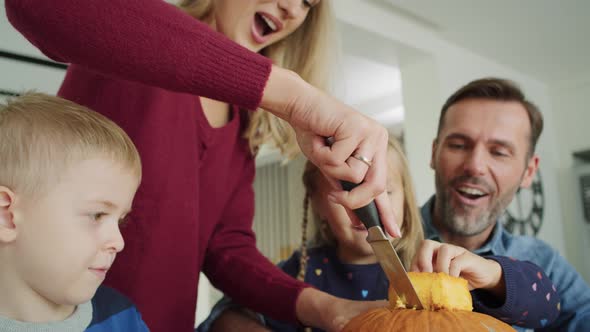 Handheld video shows of family drilling pumpkins for Halloween