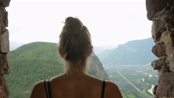 Young pretty girl enjoying beautiful landscape view over italian mountains and nature.Close up rear