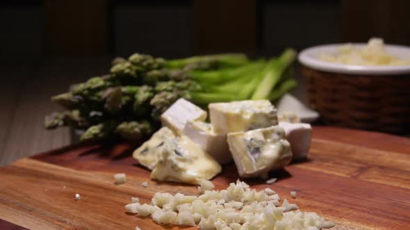 Ingredients for Delicious Cheese Sauce on Board on Background of Green Asparagus