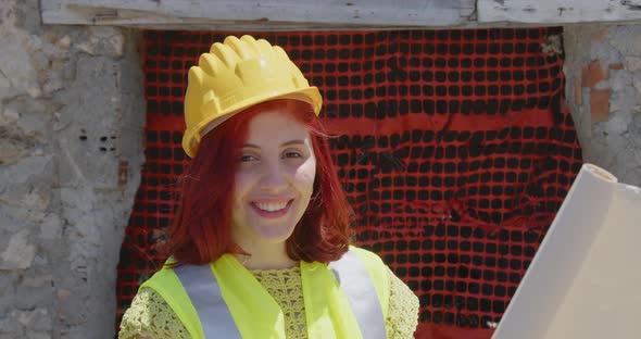 Female engineer with yellow helmet smiles