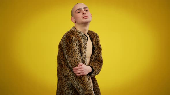 Medium Shot of Male Queer in Fur Coat Posing at Yellow Background