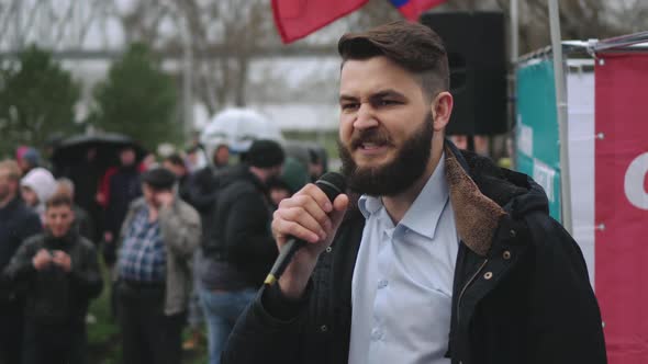 Spokesman on Stage Speaks Via Microphone with Protesting Strike Crowd in Russia