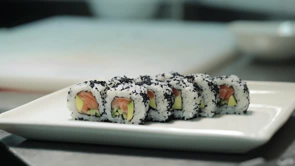 Sushi Chef in Gloves Puts the Rolls