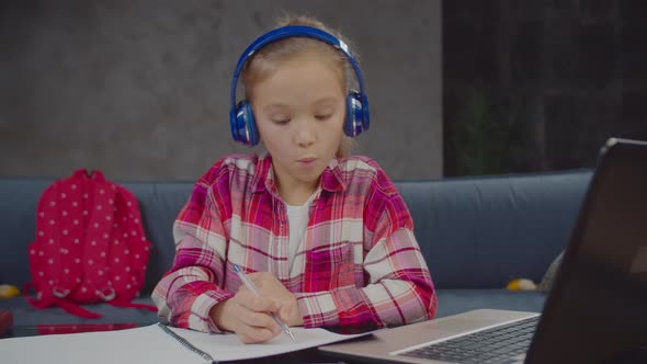 Cute Schoolgirl Doing Online Lesson with Laptop