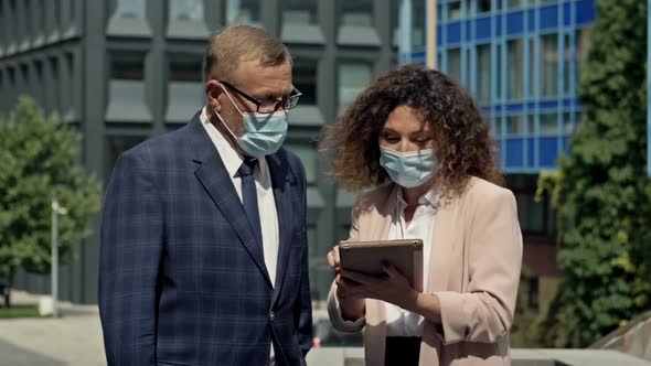 Boss and Secretary in Medical Masks Having Consultation Outdoor