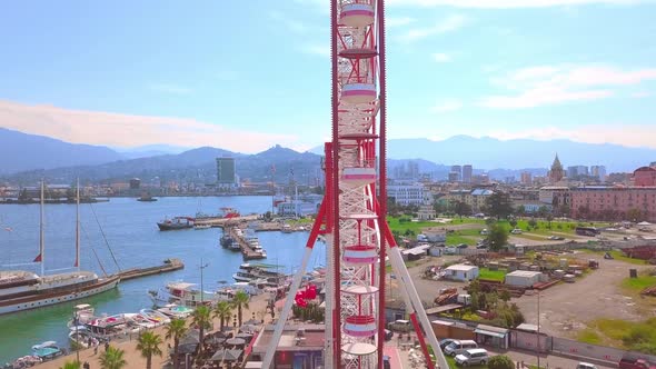 Aerial photography of a drone flying around a Ferris wheel on the seashore