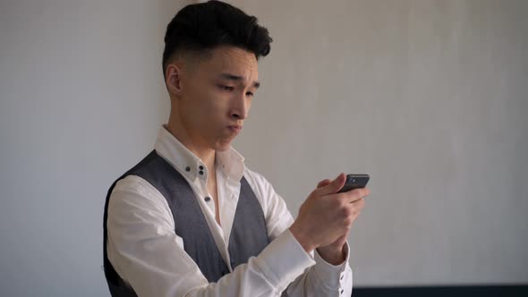 Young Asian Businessman Chooses Outfit in Online Store