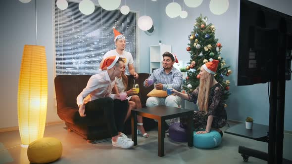 Diverse Group of Friends in Santa Hats and Party Masks Making Toasts on Christmas