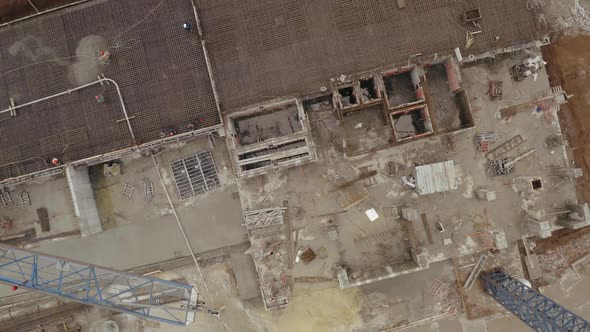 Top Vertical Shot of Modern Crane, Construction Site on Which Workers Stand and Finish Building New