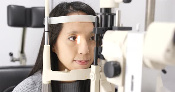 Woman checking on eye in clinic