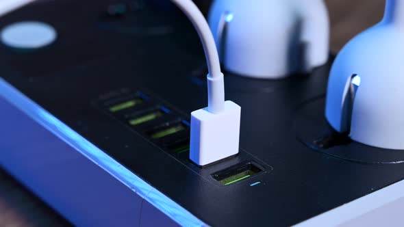 Closeup Macro of a Male Hand Plugging Cables Into a Power Outlet