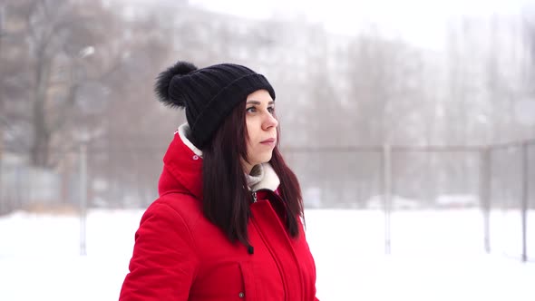 Young Woman in Hat and Red Jacket Standing on Street