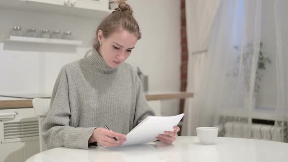 Young Woman Reacting To Failure and Reading Documents