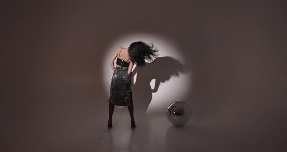Young Woman Salsa Dancer Posing Under Projectors Light