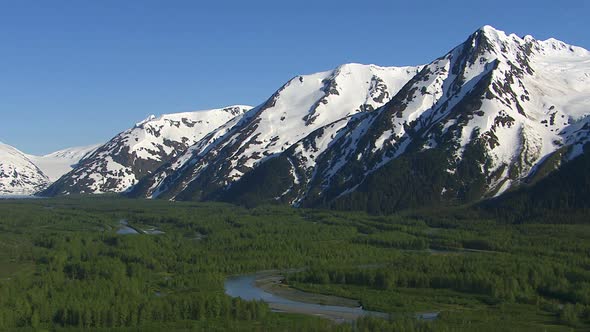 Aerial shot of forest streams and snowy mountains, Alaska