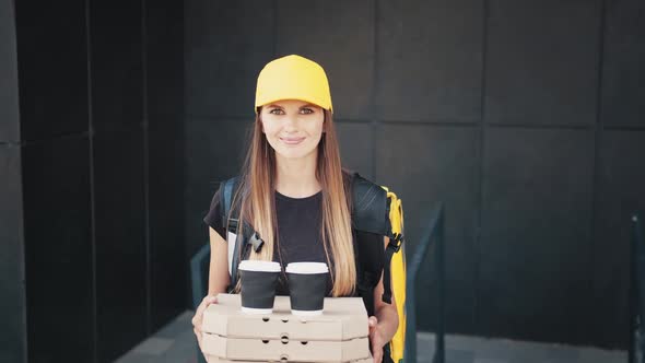 Female Courier Holding a Paper Bag with Food Coffee or Pizza