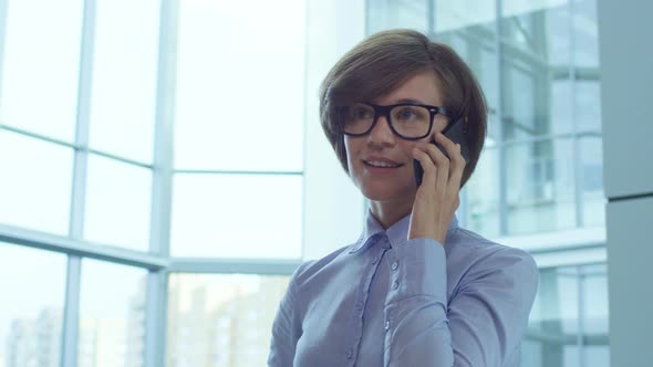 Female Manager in Eyeglasses Talking on Cell Phone