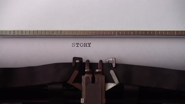 Typing word STORY on retro typewriter. Close up.