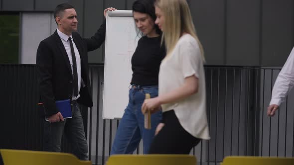 Confident Man Greeting Coworkers Entering Meeting in Slow Motion