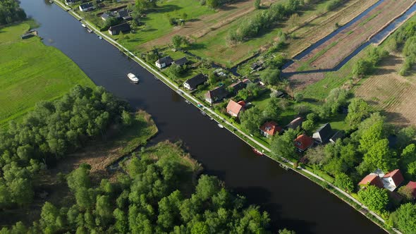 Aerial View Of A Boat Sailing On The River With Waterfront Villas At Ossenzijl In Friesland, Netherl