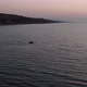 Flying around the lonely boat in the sea at sunrise - VideoHive Item for Sale