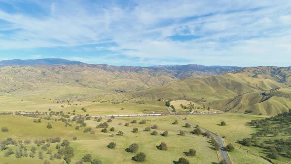 Train and Hilly Green Farmland. Kern County. California, USA. Aerial View