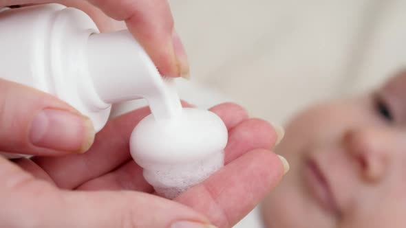 Closeup of Applying Medication Lotion on Red Baby Cheek Suffering From Dermatitis and Acne