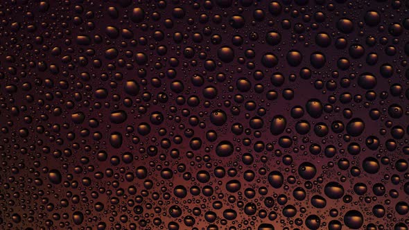 Texture water drops on the orange yellow glass - background. Moving light, changing color.