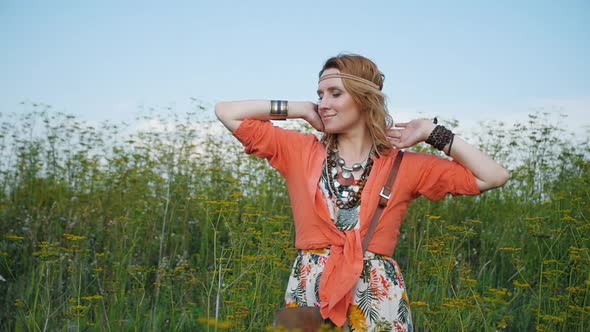 Portrait of Blonde Hippie Dancing in a Field with Flowers