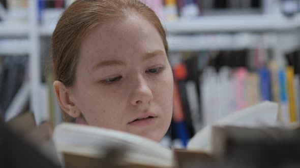 Woman Searching for Book in Library