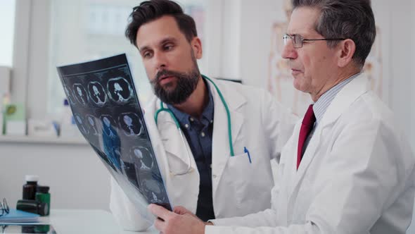 Handheld view of doctors examining the medical record. Shot with RED helium camera in 8K