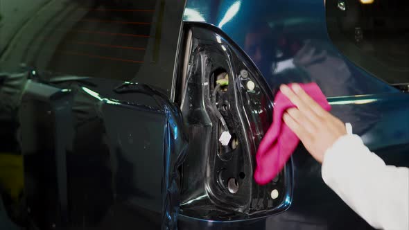 Master at the Service Station Cleaning a Car Using Rag After Applying Vinyl Film