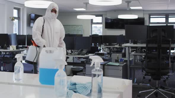 Health worker wearing protective clothes cleaning the office using disinfectant