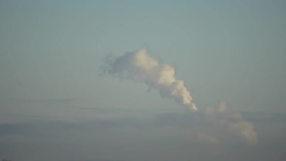 City Pipes Emit Steam Into the Atmosphere Against the City Skyline 5