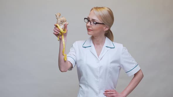 Nutritionist Doctor Healthy Lifestyle Concept - Holding Ginger Root and Measuring Tape