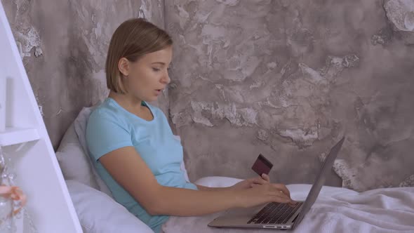 Woman Sitting in Bed Shopping Online