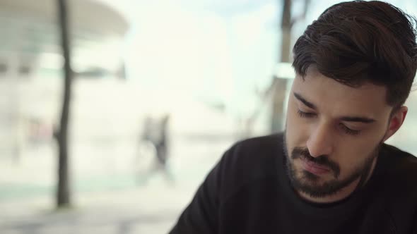 Serious Man Using Digital Device in Outdoor Cafe