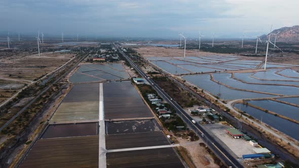 Panoramic view of salt fields around Phan rang, road and wind turbines. Aerial