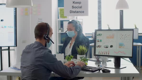 Collegues with Protection Medical Face Masks and Headphones Working in Business Office