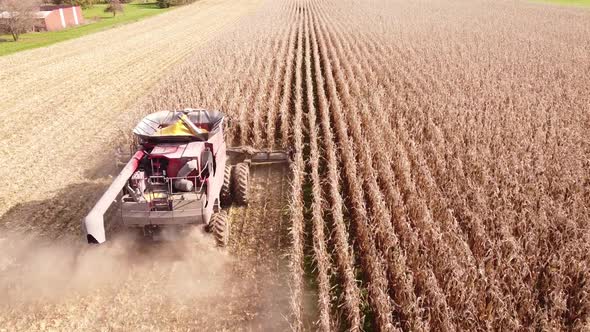 Combine Harvester At Work Gathering Corn In The Field, Southeast Michigan - aerial drone shot