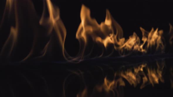 On a Black Reflective Background the Fire Ignites and Burns in Slow Motion