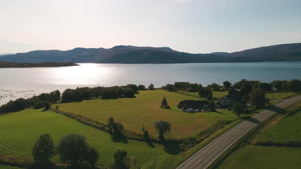 Glistening Waters Of Skjerstad Fjord From Empty Road Near Countryside House In Nordland, Norway. - a