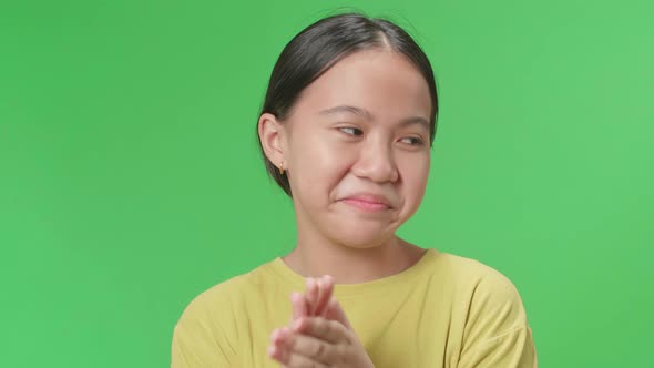 Asian Kid Girl And Emotionally Flipping Something While Clapping Hands In The Green Screen Studio