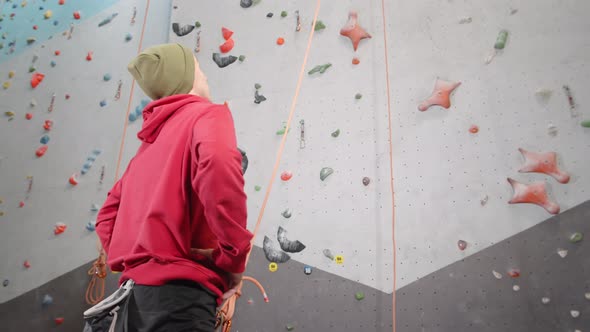 Young Sportsman Getting Ready for Climbing on Wall