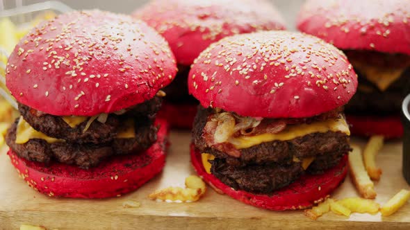 Set of Four Homemade Giant Double Becon Cheese Burgers. Served with French Fries on Wooden Board.