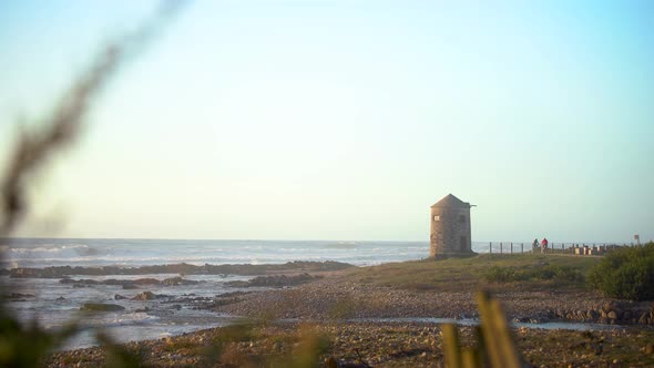 Cycling Near The Ocean With Old Windmill