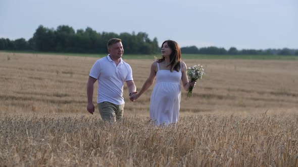 Beautiful Couple with Pregnant Woman in Forest