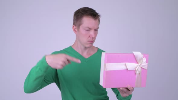 Happy Young Excited Man Giving Thumbs Up with Gift Box Ready for Valentine's Day