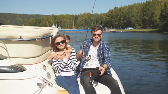 Family with Daughter Vacation Together on Sailboat in Lake