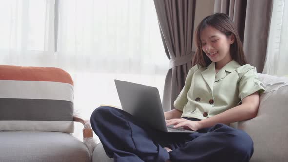 Happy young asian woman using laptop to video call or facetime to talk with friend. Stay home 